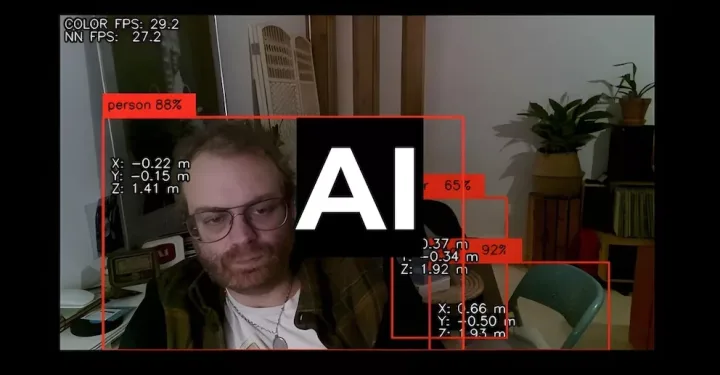 Featured image for AI - a webcam view of a man's face overlaid with red computer vision bounding boxes, technical data, and a large AI logo.
